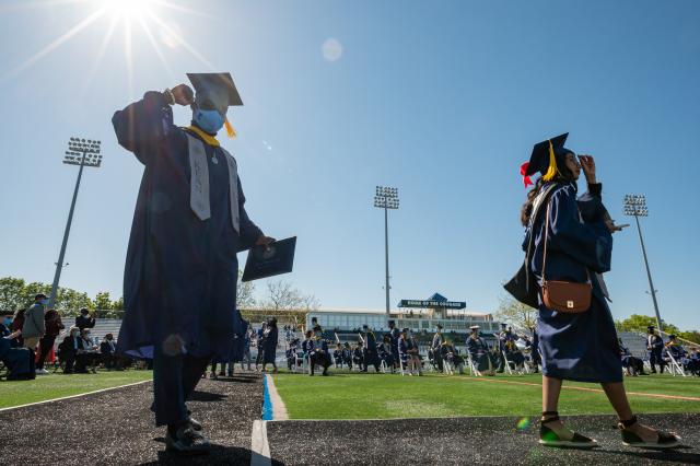 Graduate walks with diploma